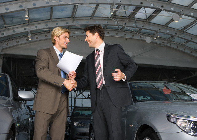 Businessman and Car Salesman Shaking Hands