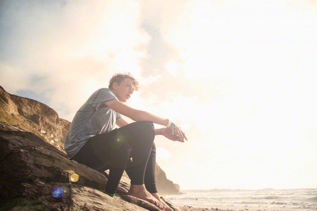 Teenage boy sitting on rocks
