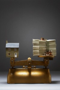 Scale with a Toy House and a Stack of Money